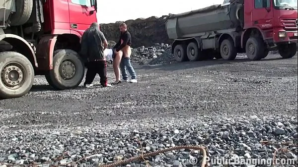 A very cute blonde young lady is fucked in public threesome at a construction site